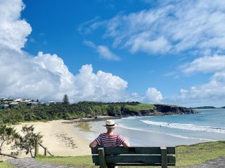 Person on a bench looking at the ocean - Accent On Travel