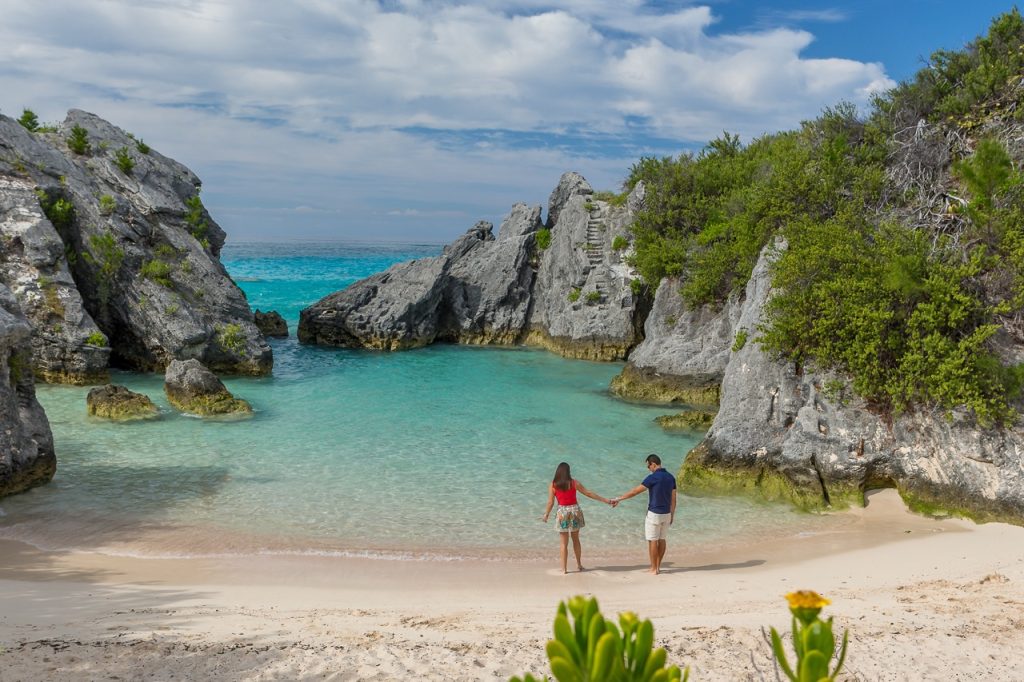Couple standing in the water Jobson's cove Beach, Bermuda bay, Caribbean - Accent On Travel