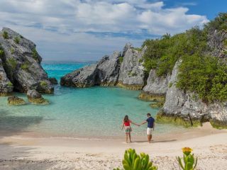 Couple standing in the water Jobson's cove Beach, Bermuda bay, Caribbean - Accent On Travel