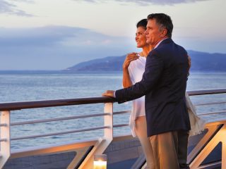 Close up of a couple looking over railings on an Oceania cruise ship - Accent On Travel