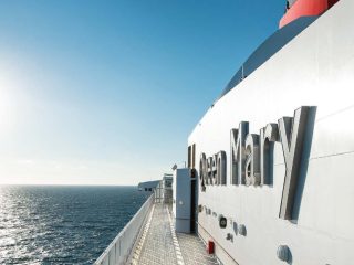 Side view of the Cunard's Queen Mary 2 logo on the ship - Accent On Travel