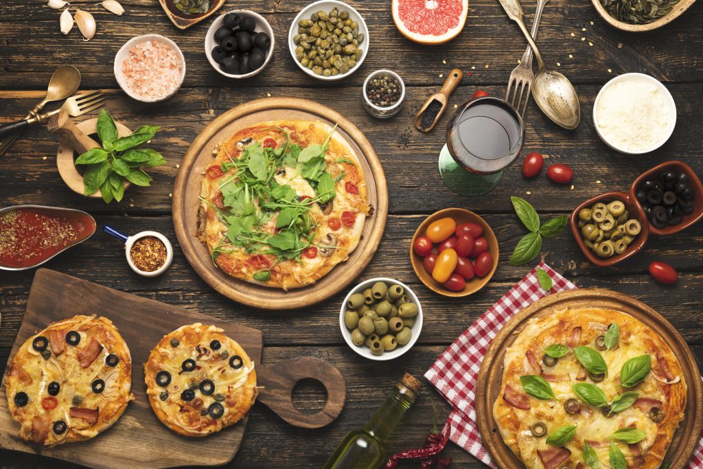 talian food on dark background with pasta, pizza, top view,- Accent On Travel