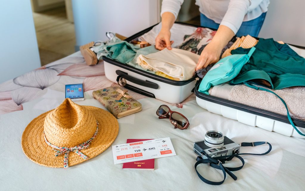 woman preparing suitcase for summer holidays - accent on travel