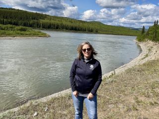 Lisarose Rosenberger standing in front of large river - Accent on Travel